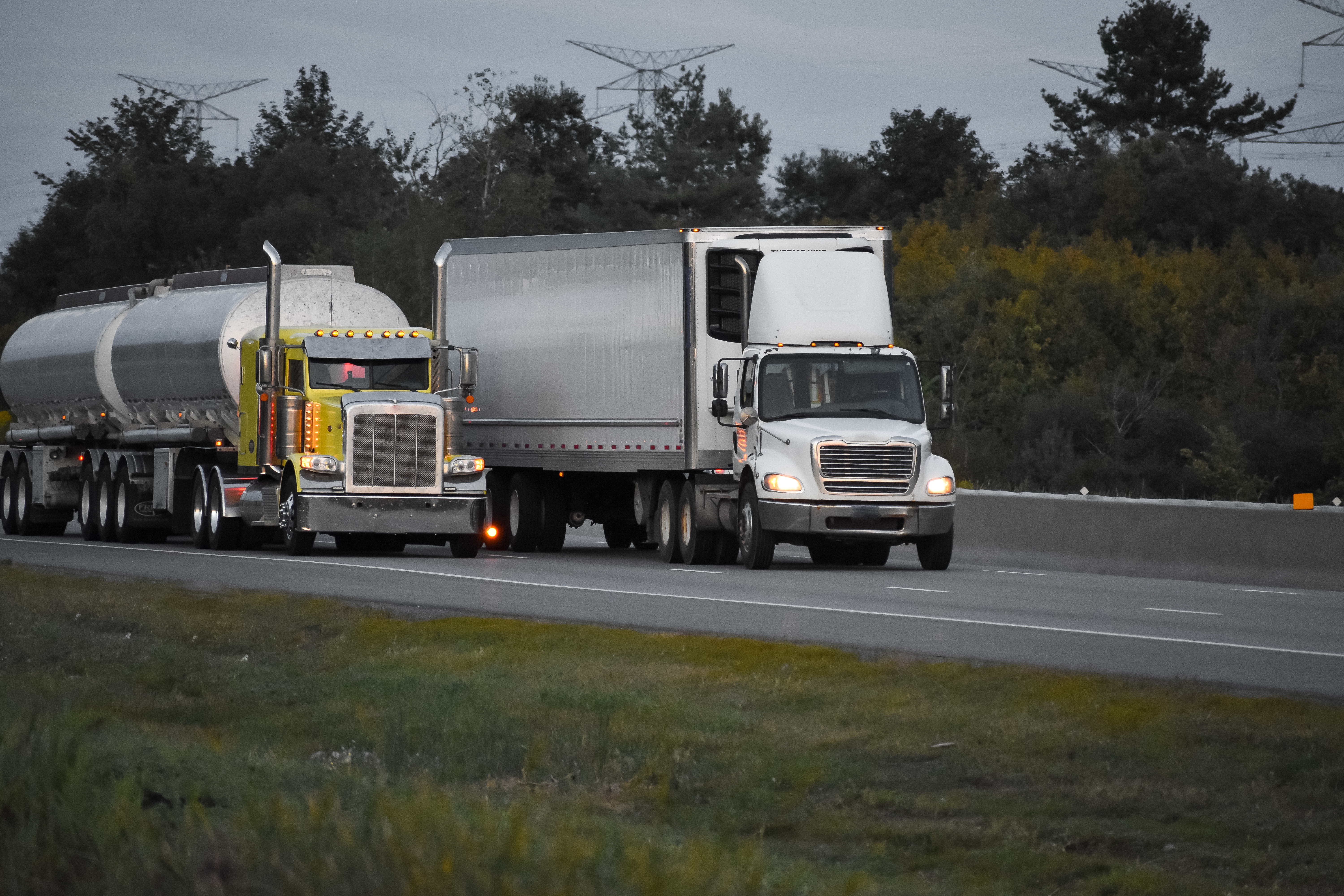 CDL Commercial truck driving in demand!! 5 trailer trucks driving road surrounded by beautiful green trees